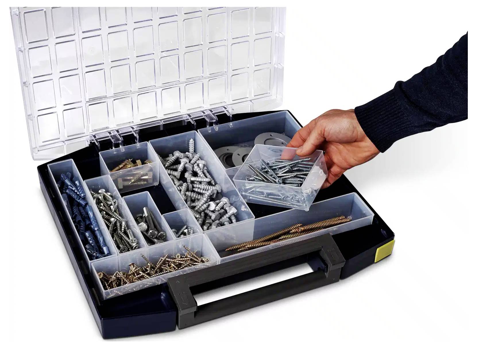 Dłoń sięga do pudełka zawierającego różne śruby i sprzęt, zorganizowane w oddzielnych przegródkach.