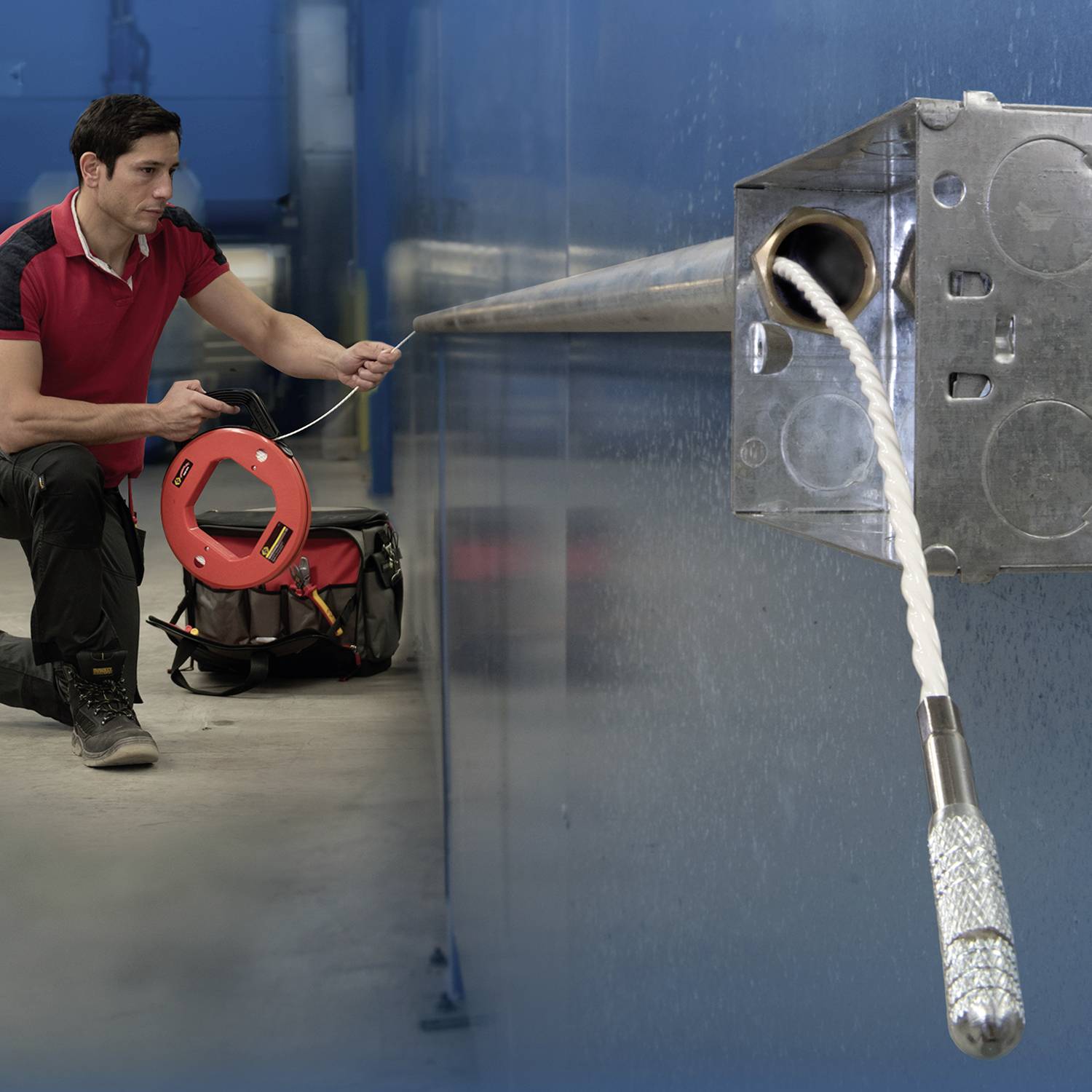 Elektryk prowadzi przewód przez metalową skrzynkę za pomocą narzędzia do wprowadzania kabli.