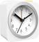 Biała, kwadratowa zegara stołowa z srebrną ramką i czarnymi wskazówkami. Wskazuje godzinę 10:10.