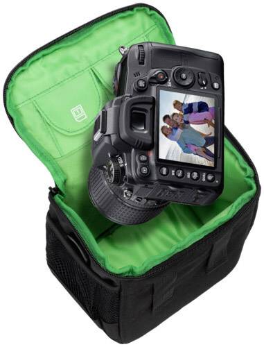 Cyfrowy aparat fotograficzny leży w otwartej torbie. Na ekranie aparatu widać zdjęcie grupki uśmiechniętych ludzi.