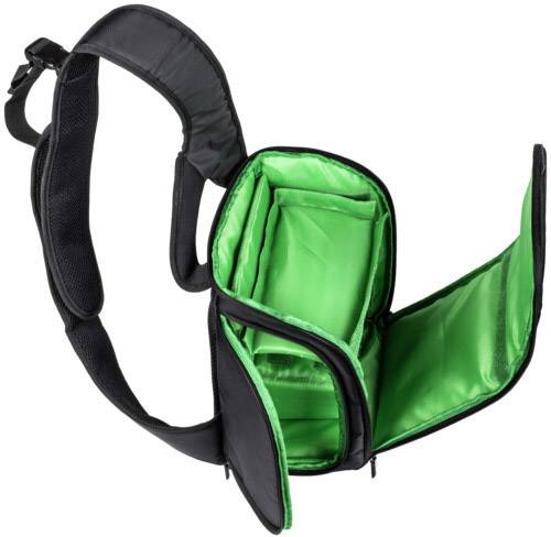 Czarna torba na aparat fotograficzny z otwartymi przegródkami, wewnątrz wyłożona świecącą zielenią. Pasek na ramię widoczny po prawej stronie.