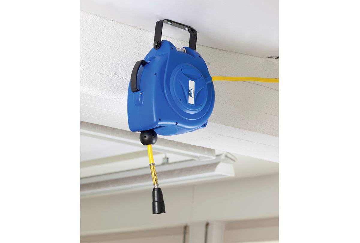 Niebieska, składana szpula z wężem powietrznym jest zamontowana na suficie, z żółtym wężem rozciągniętym w dół. Końcówka węża jest widoczna.