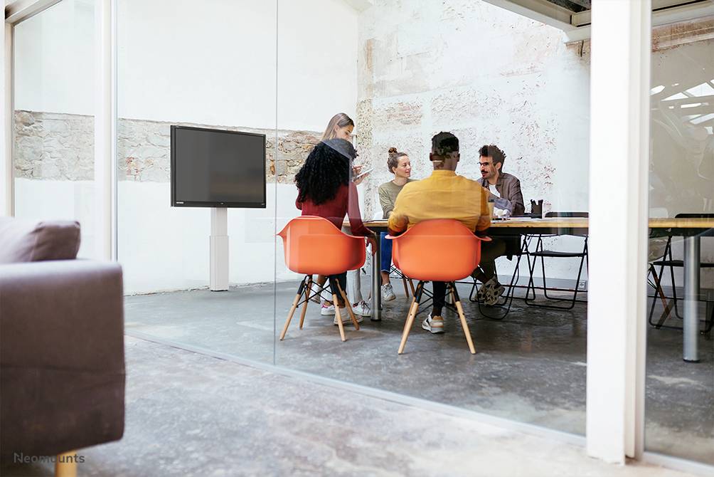 Kilka osób siedzi przy stole w jasnej, nowoczesnej sali konferencyjnej. Dyskutują i wspólnie pracują nad projektem.