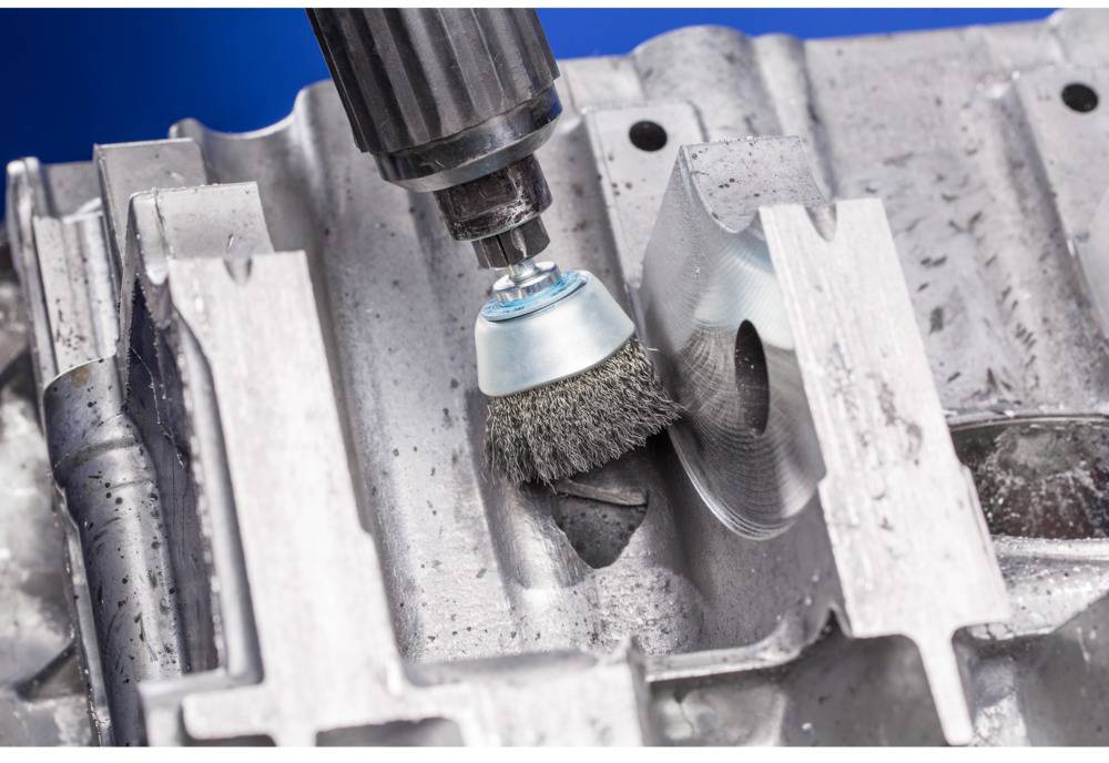 Druciana szczotka poleruje element metalowy, usuwa rdzę i wygładza powierzchnię.