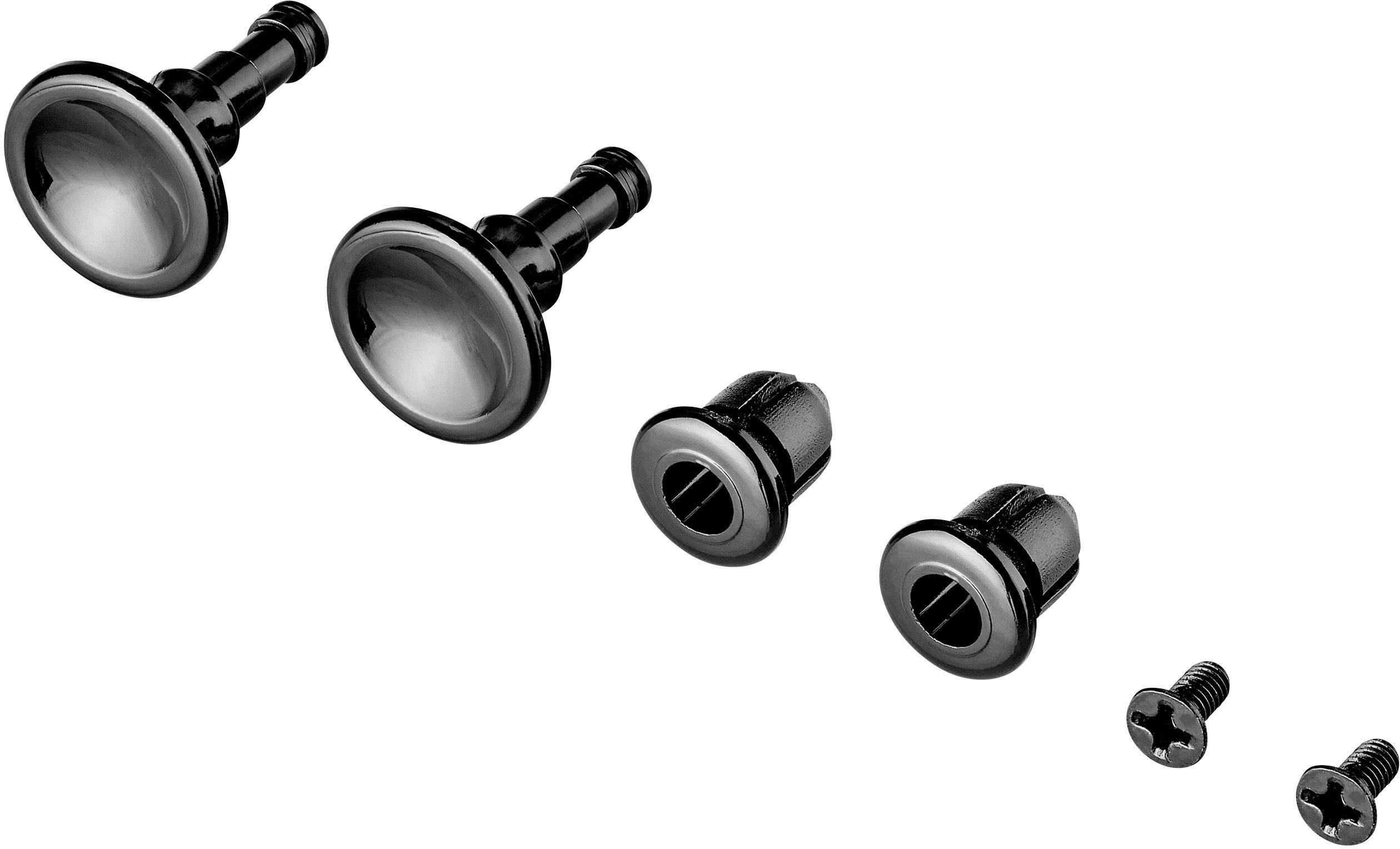 Dwa czarne guziki z metalowymi nakładkami, dwie nakrętki i dwie śruby leżą obok siebie. Komponenty do montażu mebli.