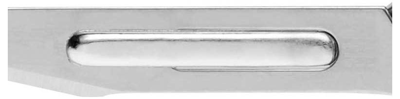 Srebrny obiekt metalowy z podłużnym, lśniącym uchwytem pośrodku. Czysty, nowoczesny styl. Głównie dekoracyjny.