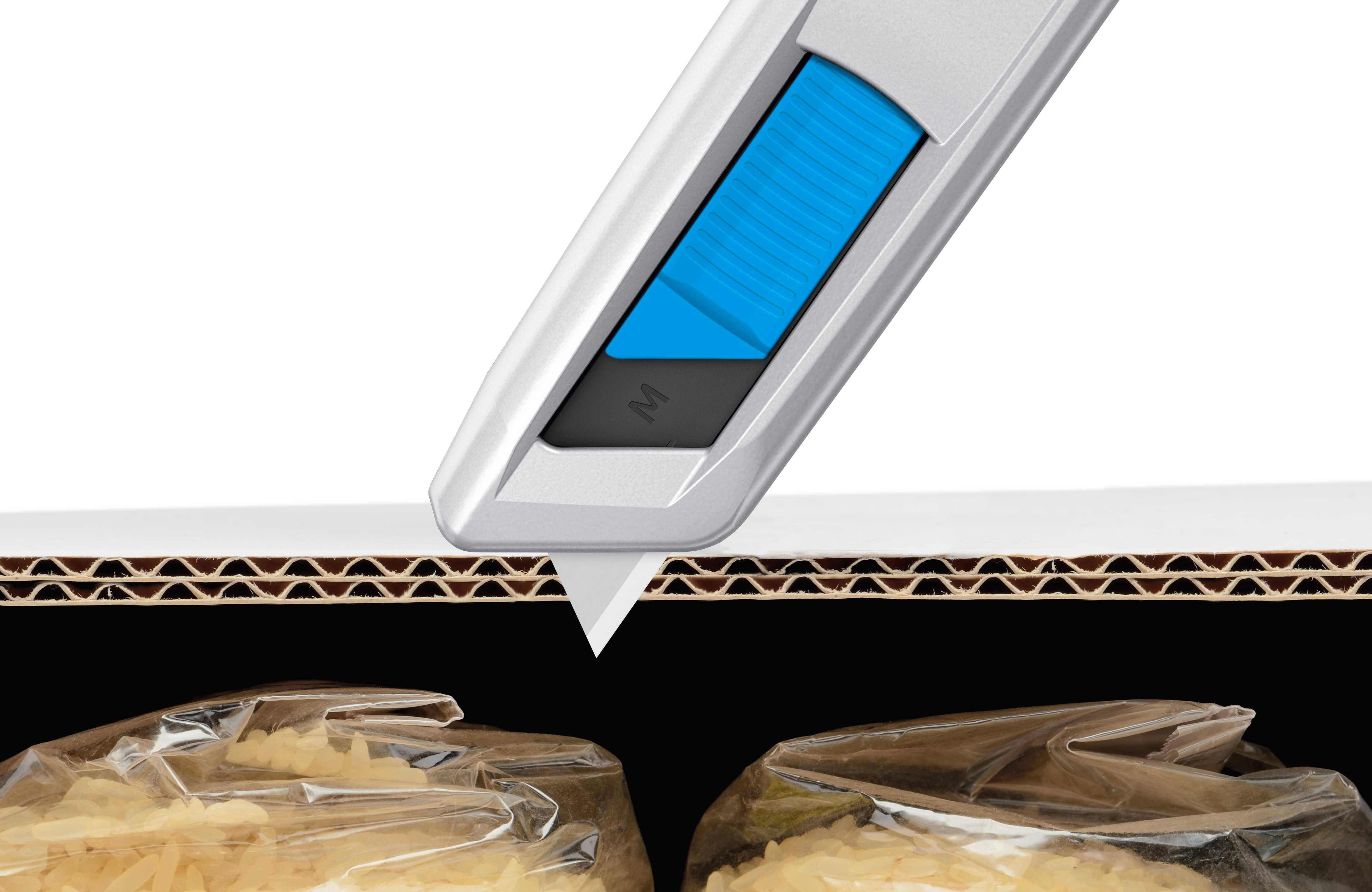 Srebrny nóż do tektury przecina tekturę falistą nad zgrzanymi workami.