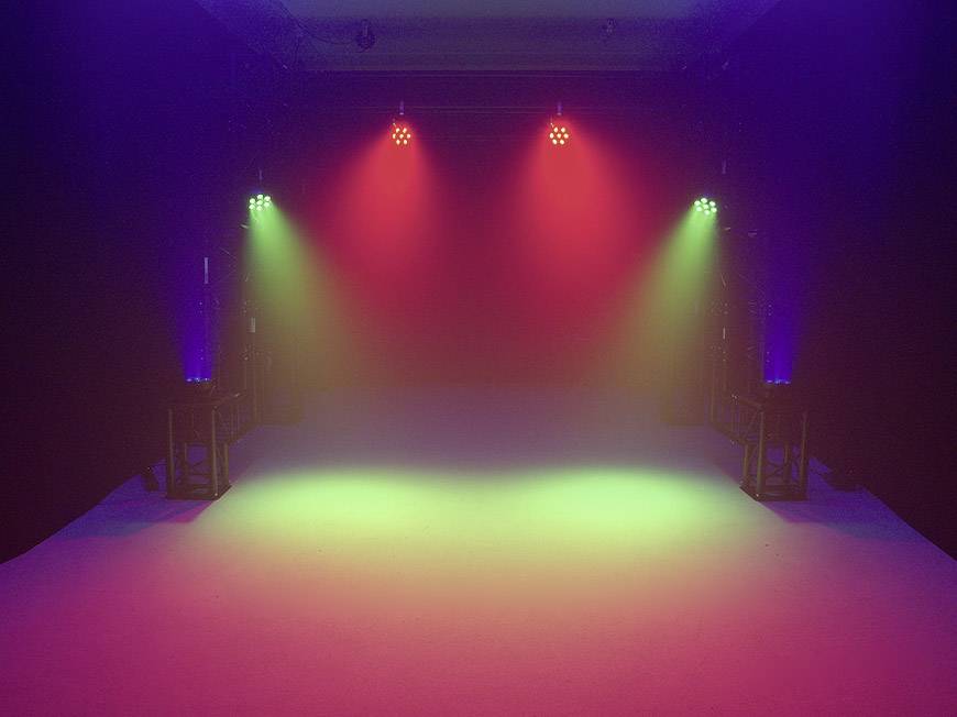 Pusty pokój z kolorowym światłem: czerwone, zielone i niebieskie światła z jasnych lamp LED tworzą atmosferę sceny lub dyskoteki.