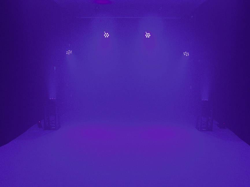 Ciemne pomieszczenie z nastrojowym fioletowym oświetleniem. Kilka świateł na suficie tworzy delikatny i tajemniczy efekt.