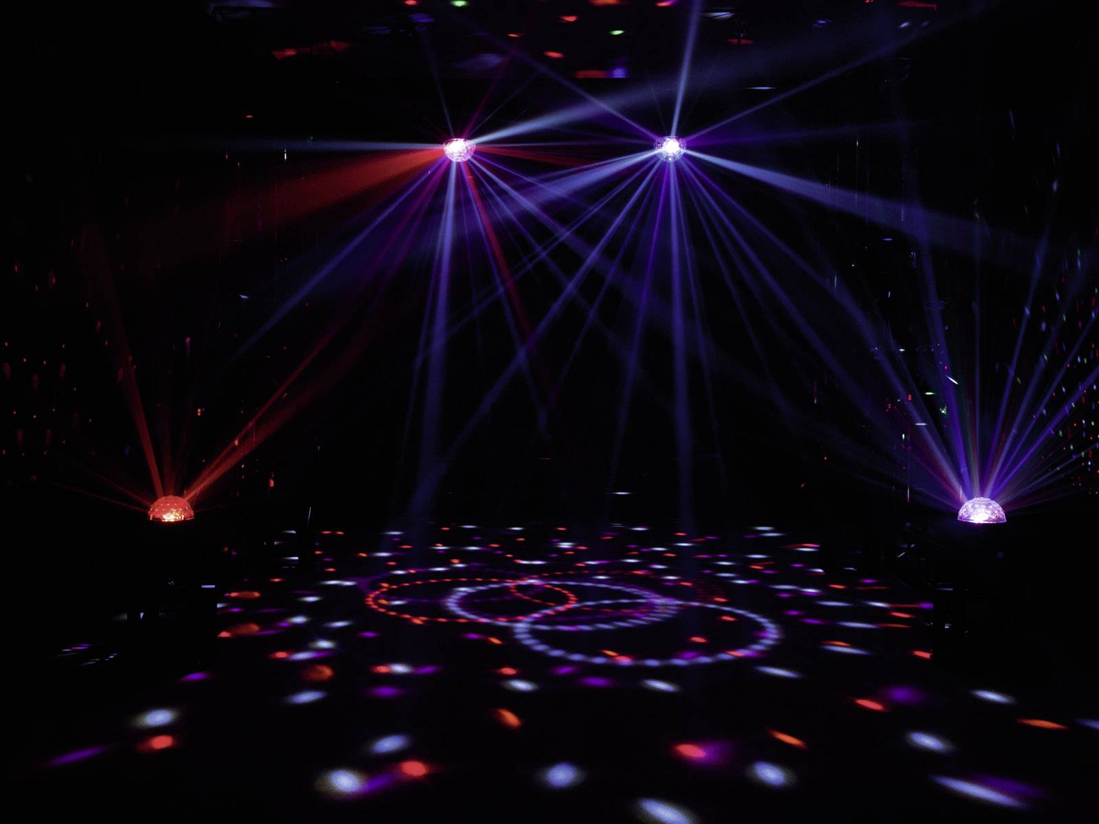 Kolorowe efekty świetlne promieniują z dwóch kul w ciemnym pomieszczeniu, tworząc dynamiczny wzór na podłodze.