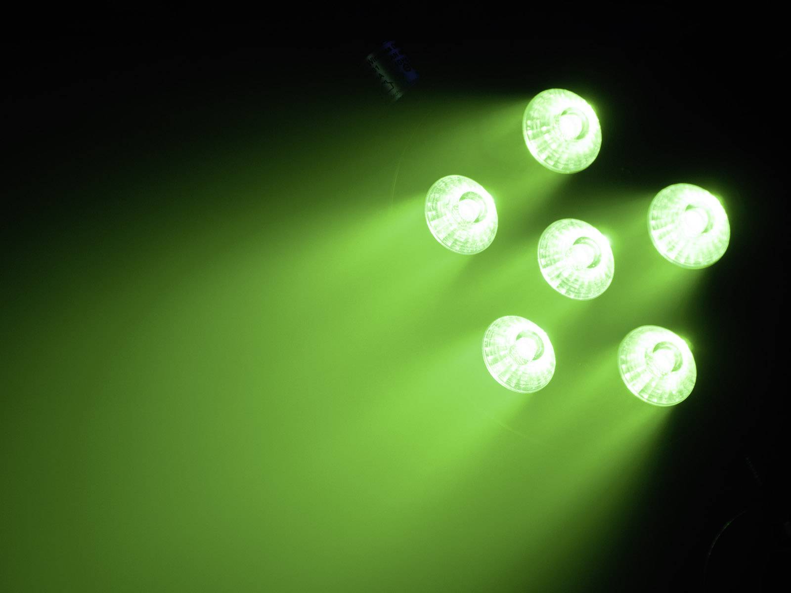 Sześć zielonych świateł w ciemnym pomieszczeniu, świecących w dół, tworzy świecące promienie i futurystyczną atmosferę.