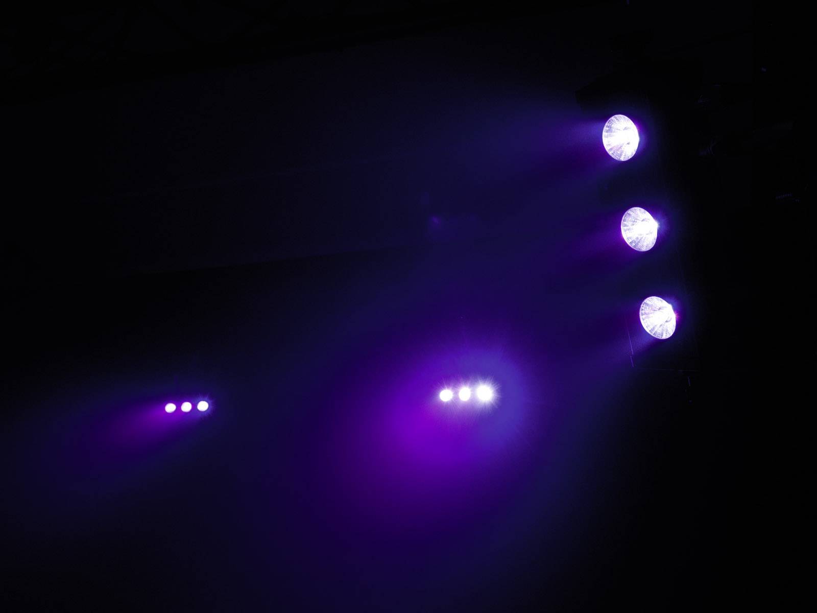 Fioletowe i niebieskie światło sceniczne oświetla ciemną scenę. Tworzy mistyczną i nastrojową atmosferę.