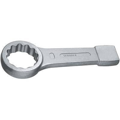 Srebrny metalowy klucz wiszący leży na płaskiej powierzchni. Klucz ma ząbkowane wnętrze.