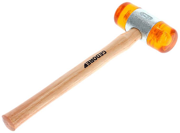 Młotek gumowy z pomarańczową główką i drewnianą rączką. Odpowiedni do prac, w których należy unikać uszkadzania delikatnych powierzchni.