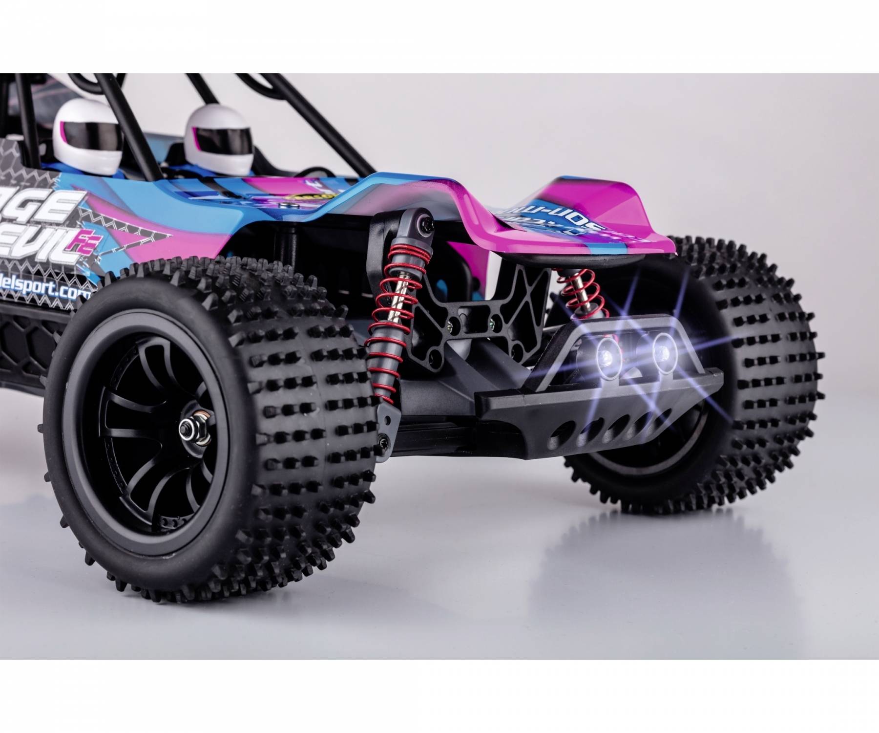 Zdalnie sterowane auto z dużymi, żłobkowanymi oponami, świecącymi reflektorami i kolorowym, sportowym wzornictwem na białym tle.