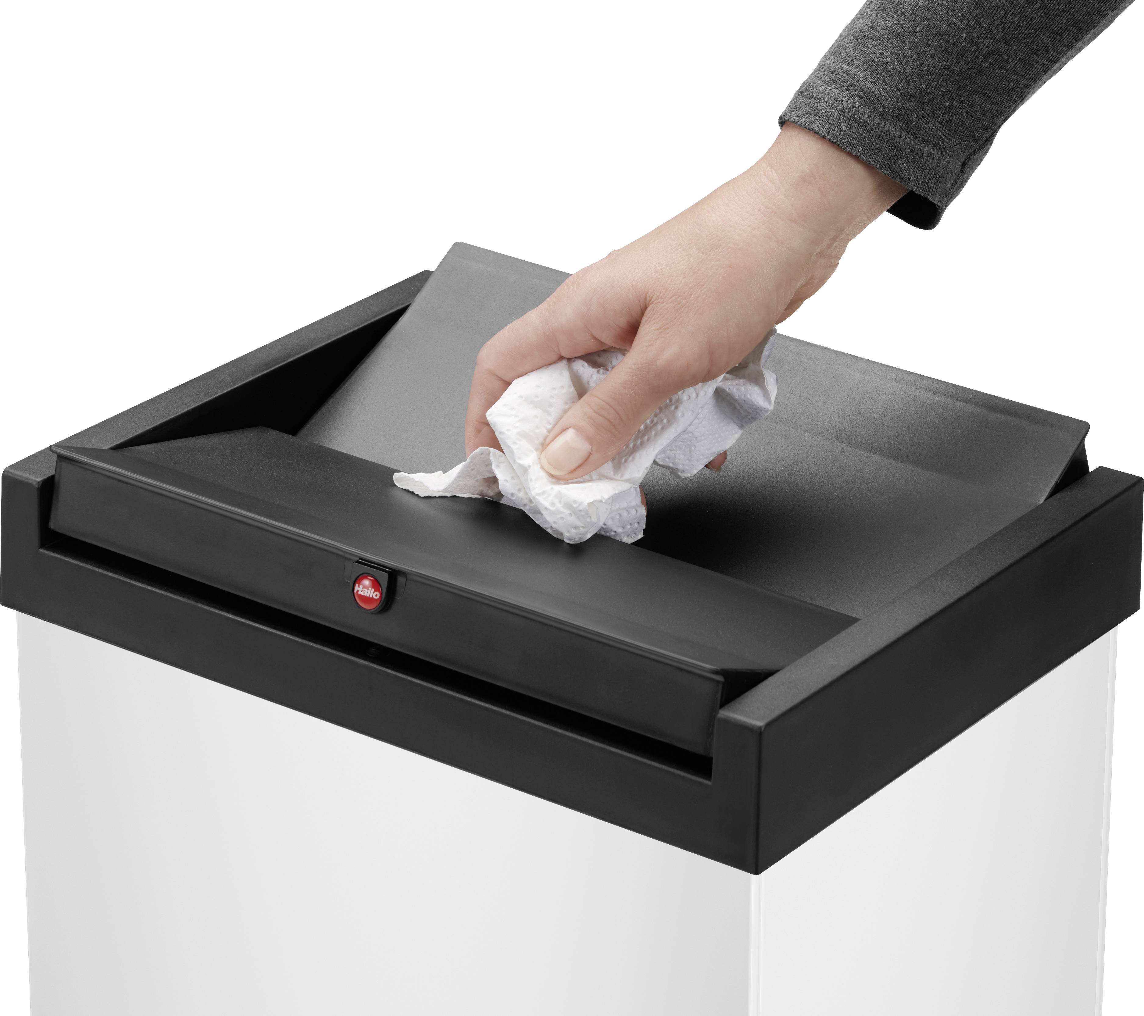 Osoba rzuca zmiętą kulką papieru do czarnego kosza na śmieci.