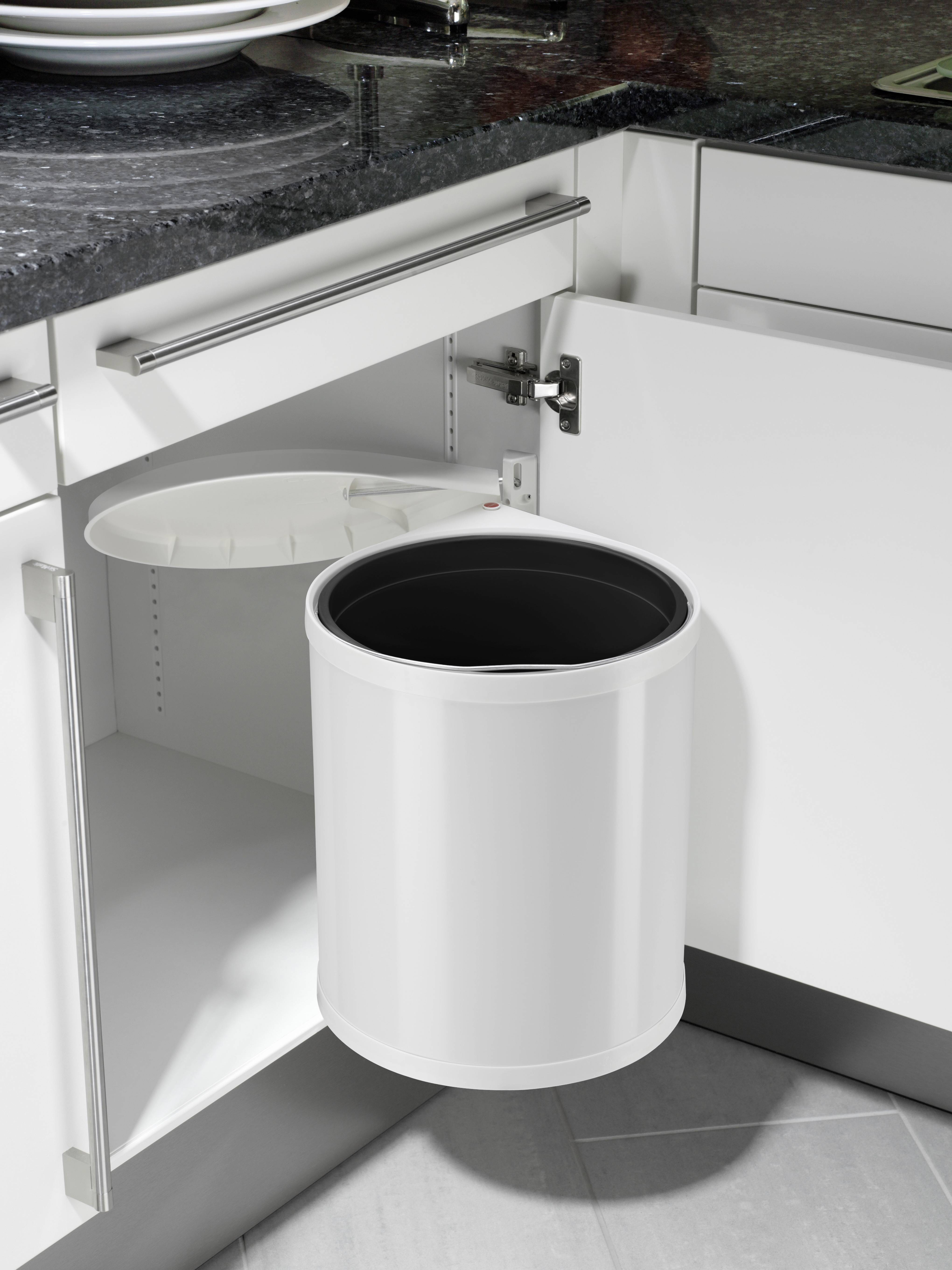 Biały kosz na śmieci jest przymocowany do wewnętrznej strony otwartych drzwiczek szafki kuchennej. Pokrywa kosza jest otwarta.