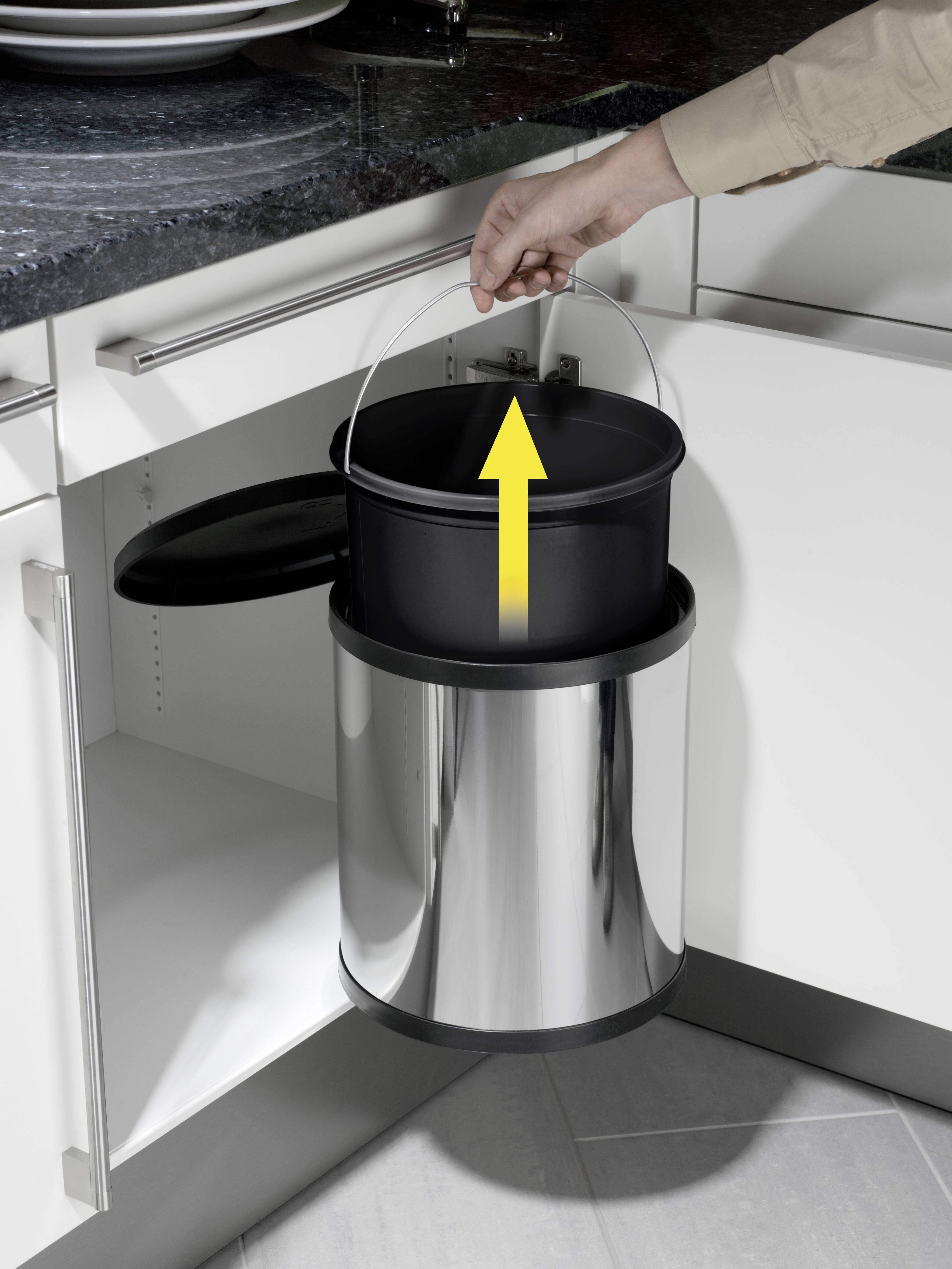 Osoba otwiera szafkę i wyjmuje wiadro z uchwytem. Wiadro znajduje się w nowoczesnej szafce kuchennej.