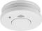 Czujnik dymu na suficie, okrągły i biały, z centralnym przyciskiem testowym.