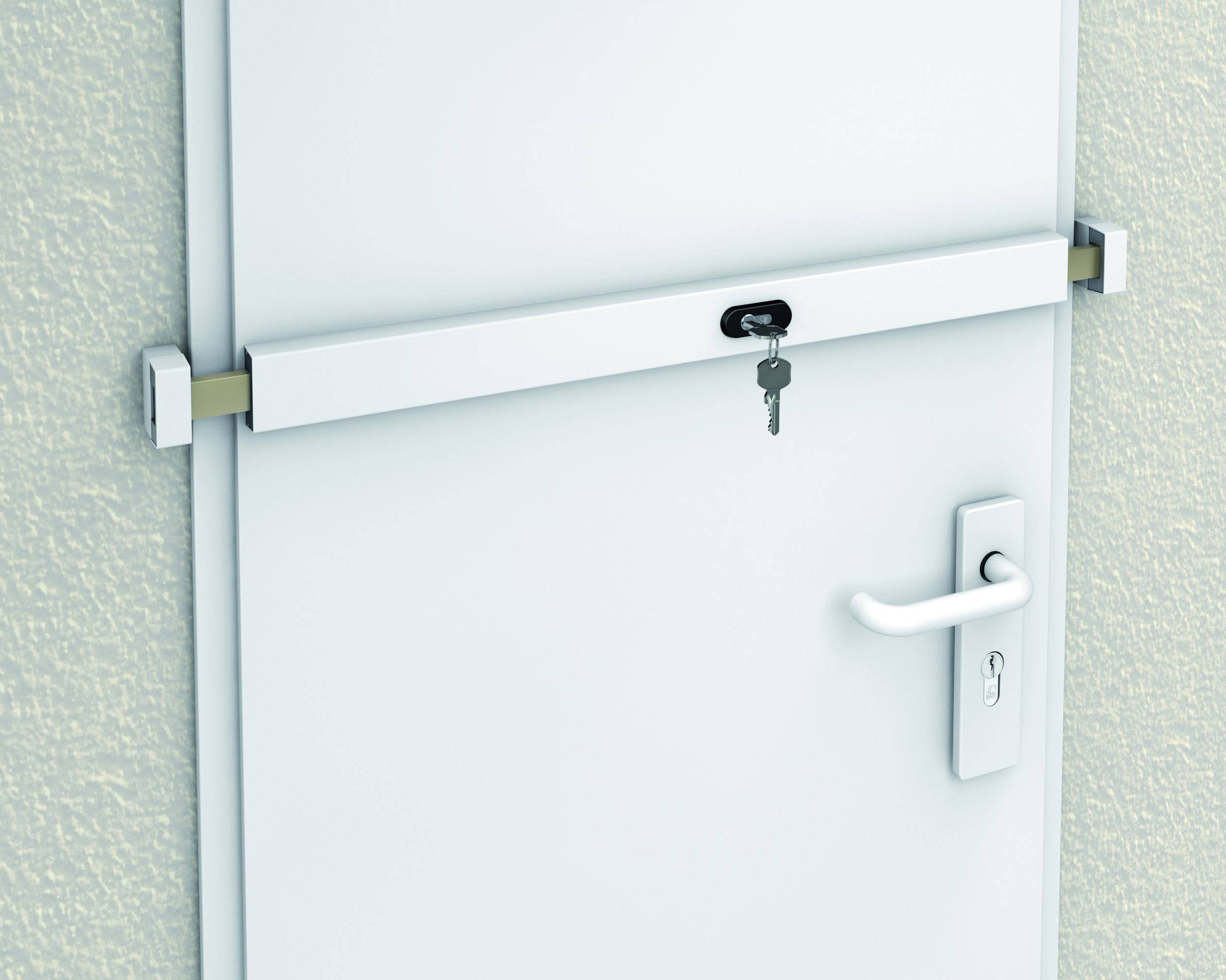 Drzwi z ryglą bezpieczeństwa i zamkiem pośrodku. Klucz jest włożony do zamka.