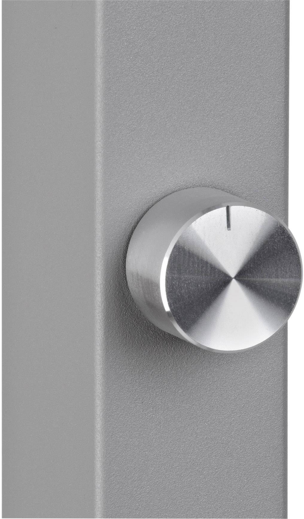 Srebrny metalowy guzik na szarej powierzchni, prawdopodobnie element sterujący lub pokrętło na urządzeniu technicznym.