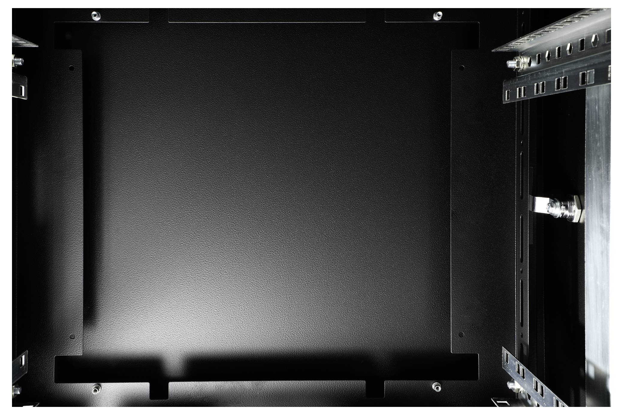 Czarny, pusty serwer lub szafa serwerowa widziane od wewnątrz, z widocznymi metalowymi mocowaniami po bokach.