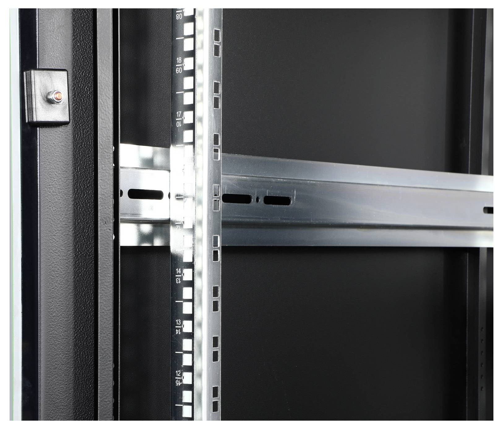 Wnętrze pustej szafy serwerowej z metalowymi poprzeczkami i uchwytami, gotowe do instalacji komponentów sprzętowych.