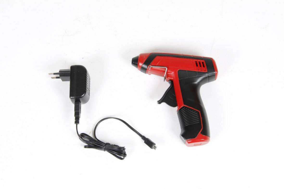 Czerwony i czarny akumulatorowy wkrętak leży obok odpowiedniej ładowarki z kablem na białym tle.