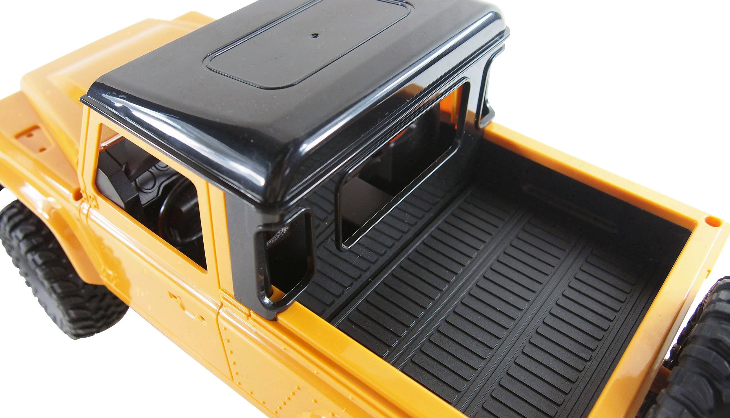 Zabawkowa ciężarówka w kolorze pomarańczowym z czarnym dachem i otwartą przestrzenią ładunkową, sfotografowana od tyłu.