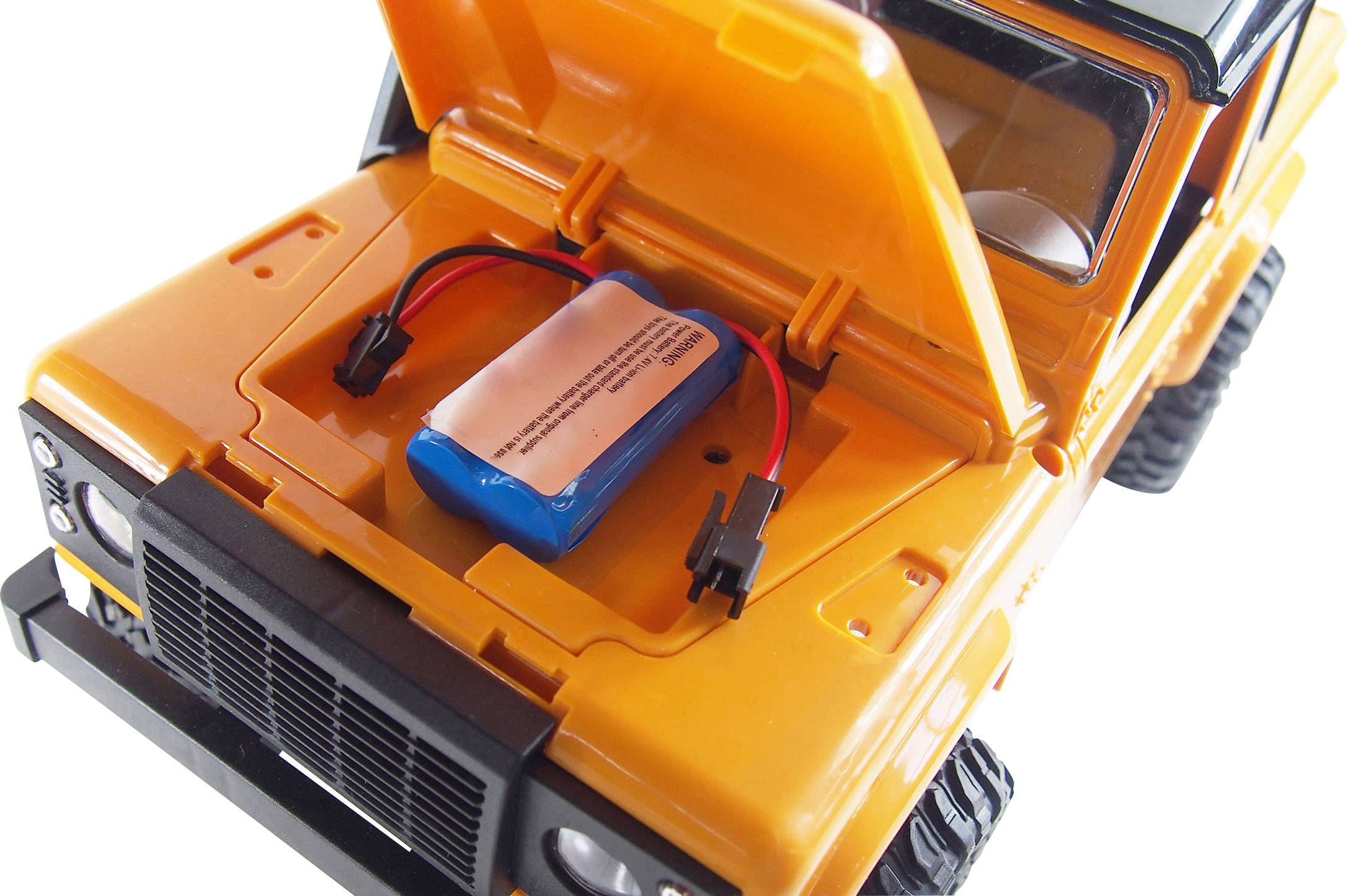 Zabawkowy samochodzik z otwartą komorą silnika, w której widoczna jest niebieska bateria. Samochód jest pomarańczowy i bardzo dobrze widoczny.