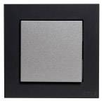 Włącznik światła z czarną ramką i srebrną powierzchnią, służący do sterowania oświetleniem w pomieszczeniu.