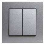 Srebrny, prostokątny włącznik światła z dwoma przyciskami, w srebrnej metalowej obudowie. Minimalistyczny design.