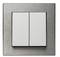 Podwójny przełącznik z ramką ze stali nierdzewnej i dwiema białymi płaszczyznami przełączającymi. Odpowiedni do sterowania światłem lub urządzeniami elektrycznymi.