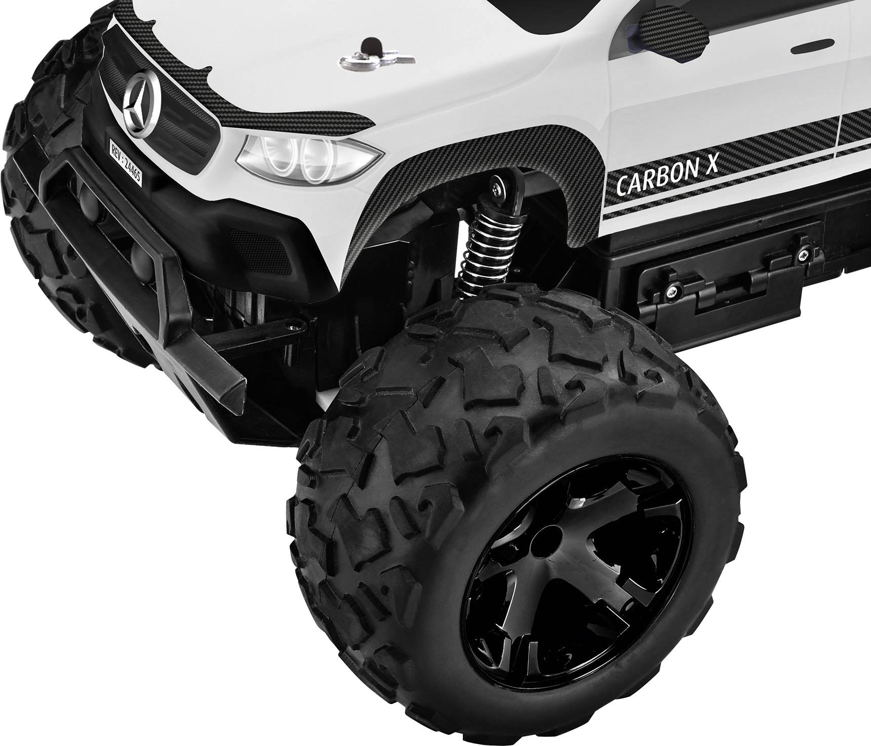 Zbliżenie zabawkowego samochodu terenowego z dużymi czarnymi kołami i białą obudową. Pojazd posiada szczegółowo wykonane nadwozie w stylu offroad.