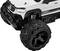Zbliżenie zabawkowego samochodu terenowego z dużymi czarnymi kołami i białą obudową. Pojazd posiada szczegółowo wykonane nadwozie w stylu offroad.