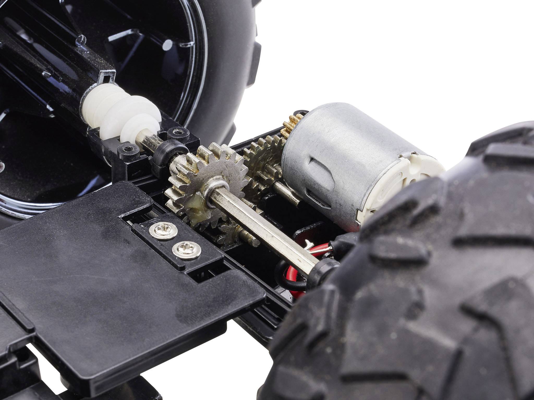 Zbliżenie zdalnie sterowanego samochodu, szczegółowo prezentujące układ przekładni zębatych i silnika w pobliżu jednego z kół.