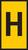 Żółta tabliczka drogowa z dużą, czarną literą 'H', wskazująca lokalizację przystanku autobusowego.