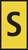 Żółta tablica z czarną literą 'S', prawdopodobnie znak informacyjny lub oznaczenie lokalizacji.