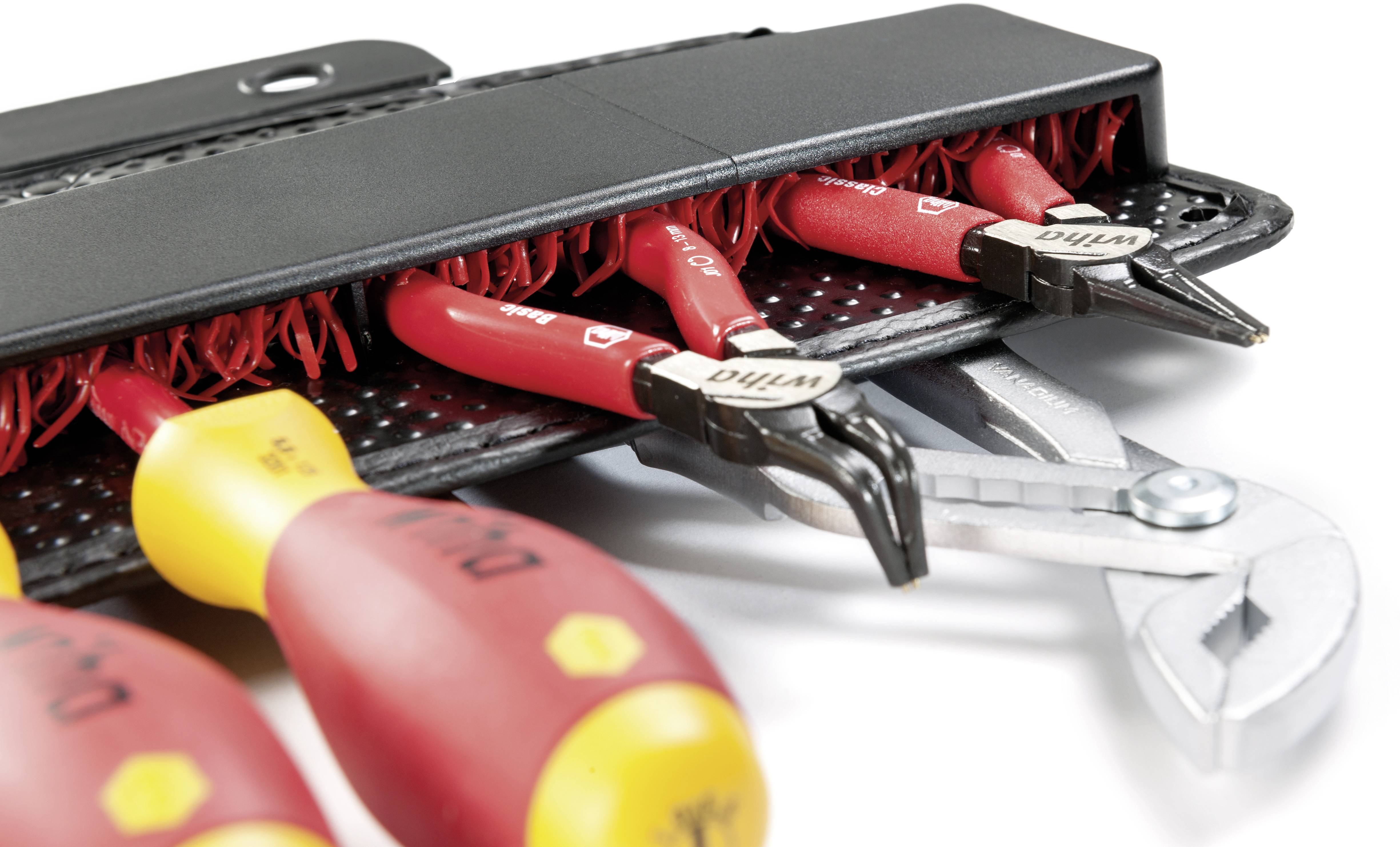 Zestaw narzędzi ręcznych w etui, w tym wkrętaki i szczypce z czerwonymi uchwytami, ułożony w sposób umożliwiający łatwy dostęp.