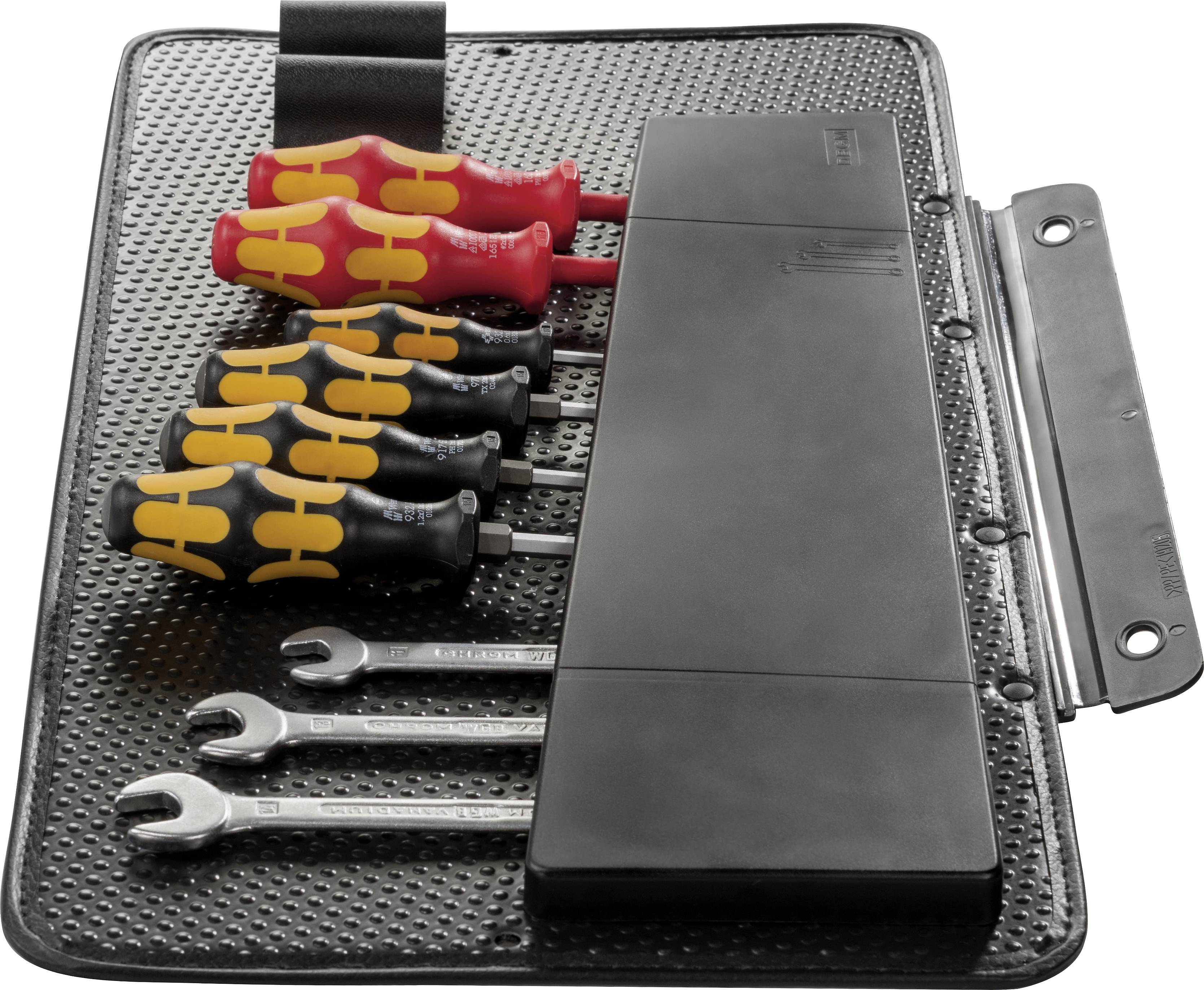 Zestaw narzędzi ze śrubokrętami i kluczami leży w uporządkowany sposób na antypoślizgowej macie.