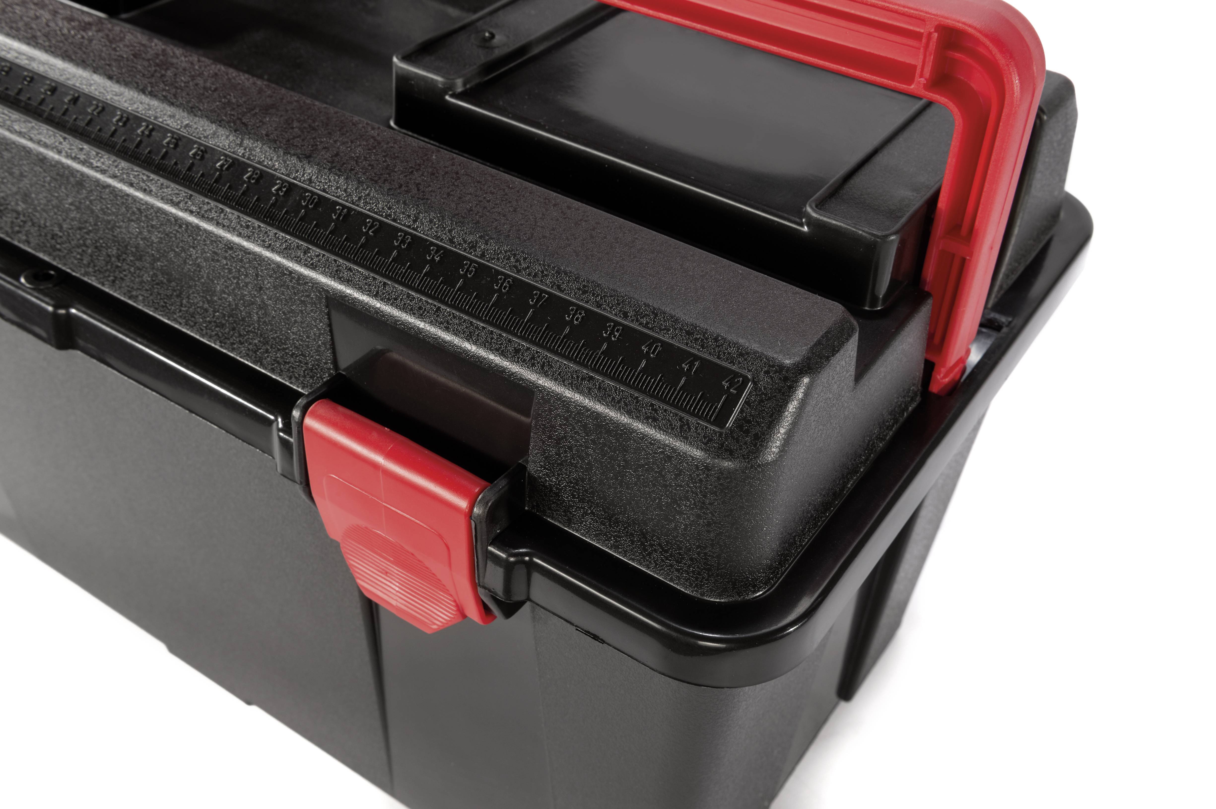 Czarny skrzynka narzędziowa z czerwonymi zamknięciami i uchwytami. Podziałka centymetrowa jest widoczna na pokrywie.