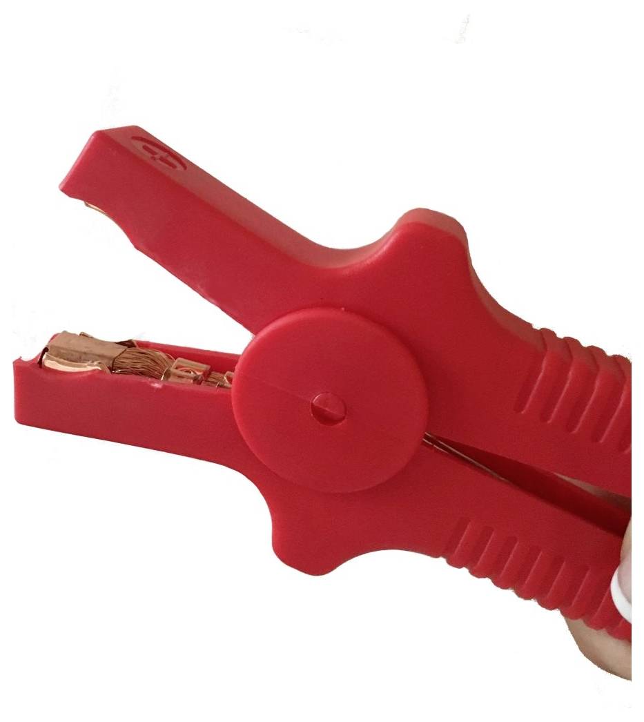 Czerwony plastikowy zacisk elektrycznywyposażony w miedziane zęby, sugerujące zastosowanie do podłączania akumulatorów samochodowych lub innych urządzeń elektrycznych.