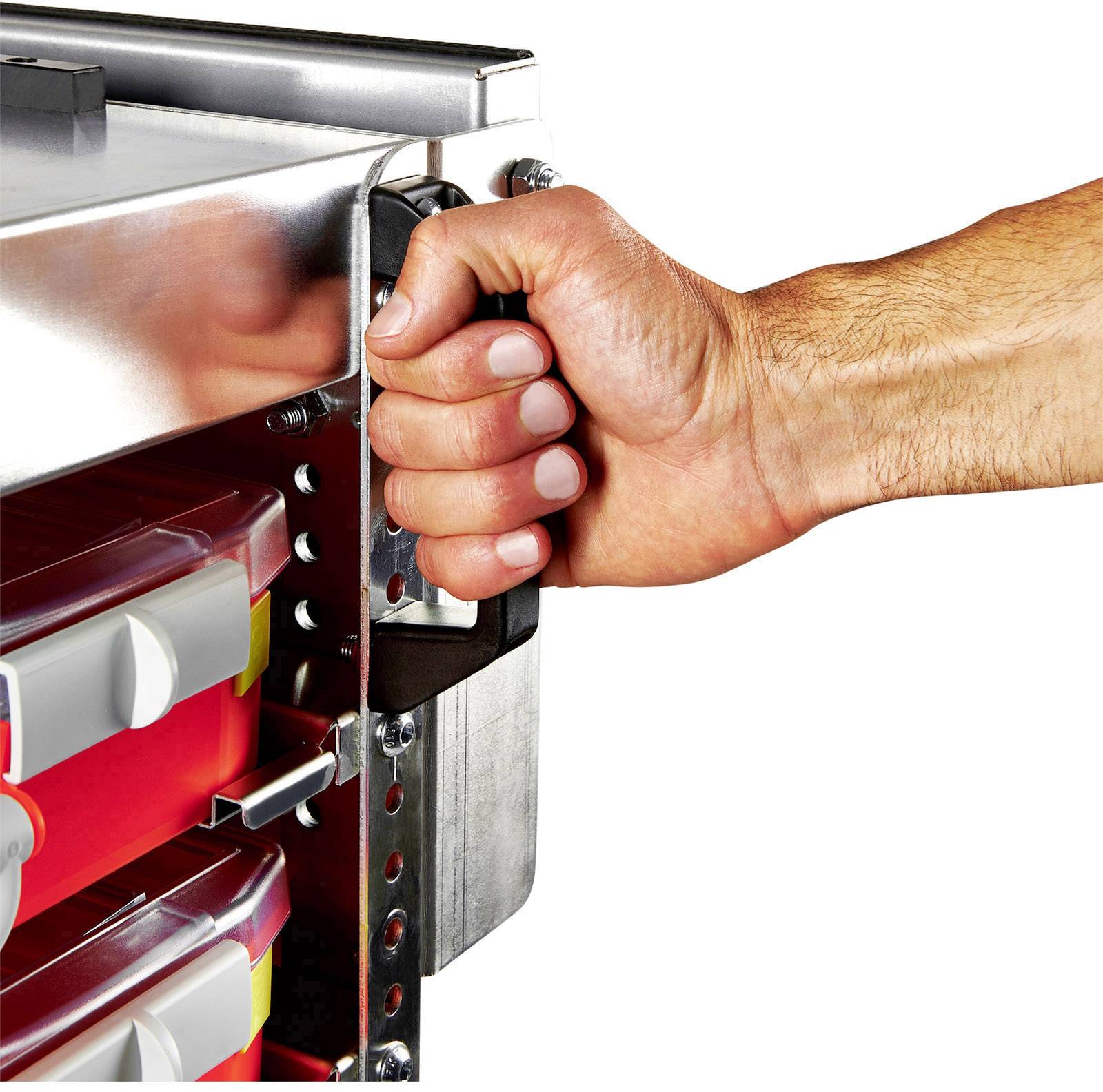 Ręka ciągnie za uchwyt metalowej szuflady, w której widoczne są czerwone pojemniki z tworzywa sztucznego.