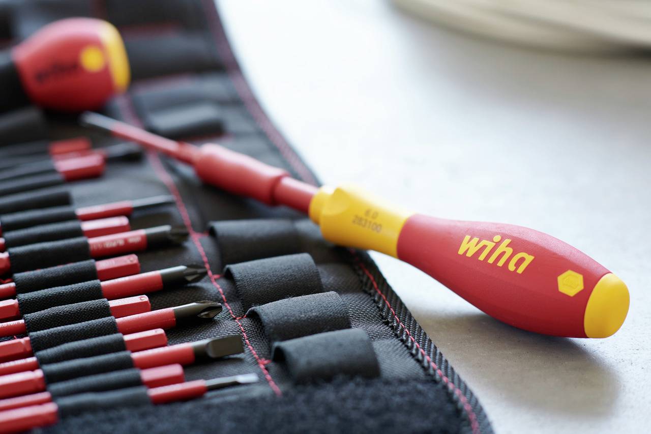 Czerwony, częściowo otwarty wałek na narzędzia Wiha, przedstawiający różne końcówki i śrubokręt z żółtą rękojeścią.