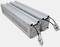 Dwie długie, metalowe, prostokątne lampy z przewodami elektrycznymi i wtyczkami na jednym końcu, na białym tle.