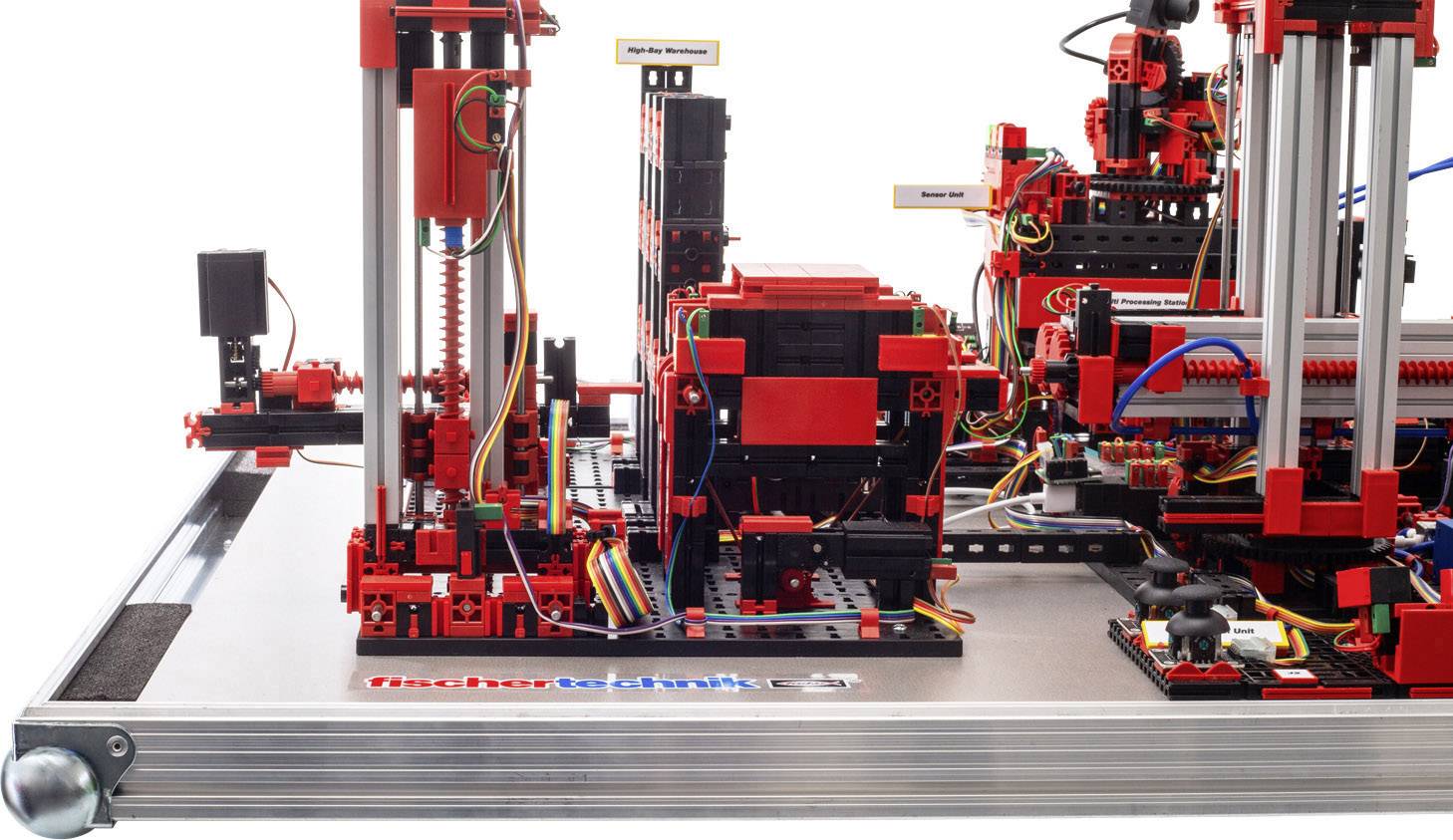 Maszyna złożona z elementów LEGO Technic na metalowej płycie. Różnokolorowe przewody łączą poszczególne komponenty, które stoją pionowo.