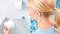 Osoba w łazience trzyma rolkę papieru toaletowego, patrząc na uchwyt ścienny z inną rolką.