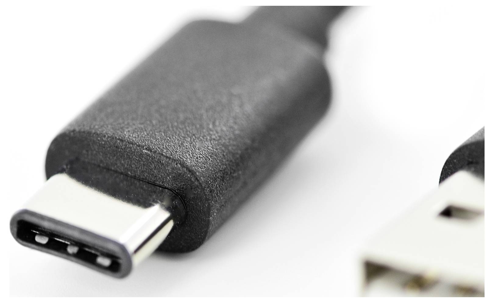 Zbliżenie czarnego złącza USB-C z rozmytym wtykiem USB-A w tle.