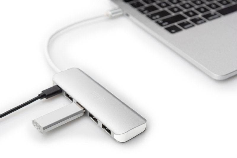 Laptop jest podłączony do stacji dokującej z wieloma portami USB za pomocą adaptera. Do stacji podłączone są dwa urządzenia.