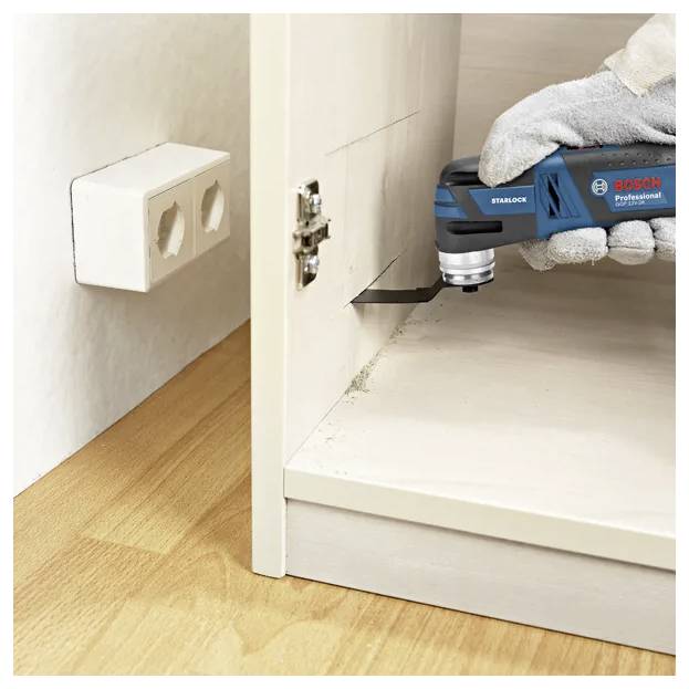 Osoba używa profesjonalnego elektronarzędzia Bosch, aby precyzyjnie i z łatwością wyciąć krawędź drewnianej szafki.